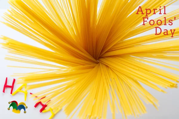 Beyaz arka planda izole edilmiş çiğ spagetti makarnası. Hamur kabın içine konur. Kapak, el kitabı için kart 1 Nisan şakası. seçici odak