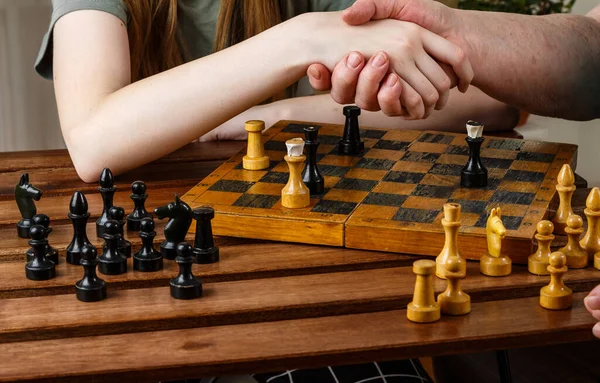 Son sınıftaki kadın satrançtan sonra torununun elini sıkıyor. Satranç oynamada strateji düşünmek ve planlamak, yakın plan, seçici odak, kopyalama alanı