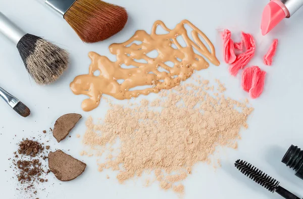 Kadınlar için dekoratif kozmetik. Makyaj malzemeleri. Beyaz arka planda kozmetik ürünleri. Beyaz arka planda makyaj fırçaları, ruj, göz farı, pudra, fondöten ve rimel var. seçici odak