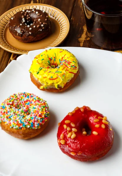 Tatlı, bir grup jöleli çörek. Fast sweet food konsepti, fırın tasarım elementleri beyaz ve kahverengi tabaklar içinde ahşap masa üzerinde. seçici odak