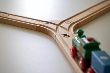 Tahta bir raydaki model tren raydaki bir çatala yaklaşıyor.