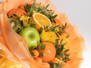 Beyaz arka planda yeşil elma ve mandalinalı yenilebilir buket.