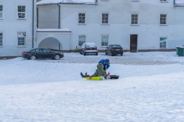 Narva Estonya. 5 Aralık 2021 Çocuklar kayağa biniyor. Kış eğlencesi.