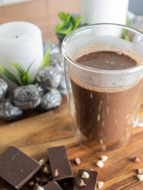 Sıcak çikolata, cam bardakta kakao, arka planda Noel süslemeleri.,