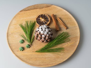 Tahta tepside, çikolata koni şeklinde tatlı. Kötü bir geçmişi var. Noel hediyesi.