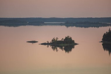 Denizin üzerinde yaz şafağı. İskandinavya doğası. Denizdeki adalar. Finlandiya. Turku Archipelag
