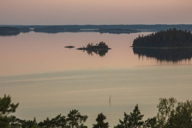 Denizin üzerinde yaz şafağı. İskandinavya doğası. Denizdeki adalar. Finlandiya. Turku Archipelag
