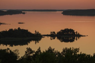 Denizin üzerinde yaz şafağı. İskandinavya doğası. Denizdeki adalar. Finlandiya. Turku Archipelag
