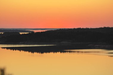 Denizin üzerinde yaz şafağı. İskandinavya doğası. Denizdeki adalar. Finlandiya. Turku Archipelag