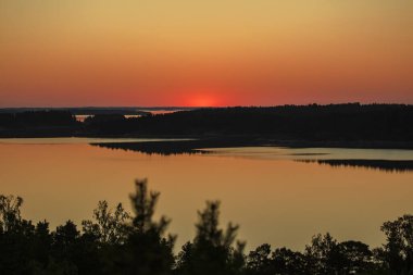 Denizin üzerinde yaz şafağı. İskandinavya doğası. Denizdeki adalar. Finlandiya. Turku Archipelag