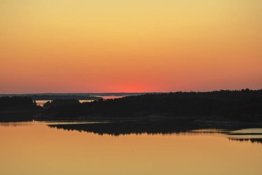 Denizin üzerinde yaz şafağı. İskandinavya doğası. Denizdeki adalar. Finlandiya. Turku Archipelag