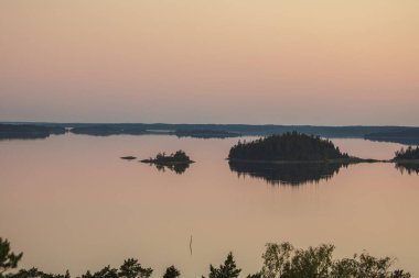 Denizin üzerinde yaz şafağı. İskandinavya doğası. Denizdeki adalar. Finlandiya. Turku Archipelag
