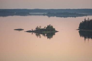 Denizin üzerinde yaz şafağı. İskandinavya doğası. Denizdeki adalar. Finlandiya. Turku Archipelag