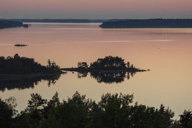 Denizin üzerinde yaz şafağı. İskandinavya doğası. Denizdeki adalar. Finlandiya. Turku Archipelag