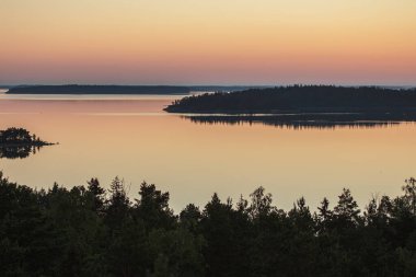 Denizin üzerinde yaz şafağı. İskandinavya doğası. Denizdeki adalar. Finlandiya. Turku Archipelag