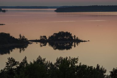 Denizin üzerinde yaz şafağı. İskandinavya doğası. Denizdeki adalar. Finlandiya. Turku Archipelag