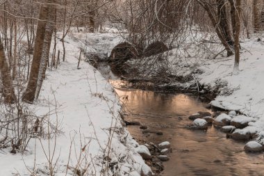 Karlı yollarda küçük bir dere.