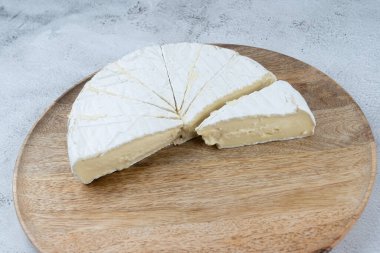 Yan görünüş, yuvarlak beyaz peynir. Tahta bir tabakta geleneksel sütlü süt ürünü. Ev, Country tarzı.