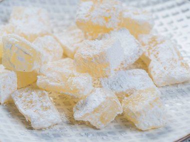 Geleneksel Türk ve Yunan jöleli şekeri bir tabakta pudra şekerle. Arap usulü şekerleme. Yakın plan.