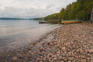 Deniz Burnu. Sakin bir yaz günü. Rezervuardaki şeffaf su, kayalık zemini ve tekne için olan arabayı görebilirsiniz.