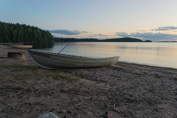 Deniz burnu ve kıyıda bir tekne. Huzurlu, sakin, akşam gökyüzü ve deniz. Doğal arka plan. Yaz akşamı..
