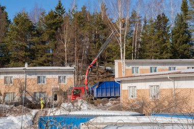 Espoo 'da. Finlandiya 14 Mart 2022. İnşaat çalışmaları devam ediyor. İşçi ağaçların dallarını kesiyor