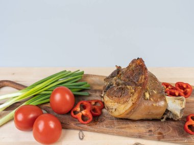 Fırında domuz budu ve kesme tahtasında sebzelerle pişirilmiş.