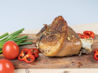 Fırında domuz budu ve kesme tahtasında sebzelerle pişirilmiş.