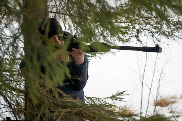 春の森にライフルを持った男ハンターはライフルを持って獲物を待つハンターは撃つ — ストック写真