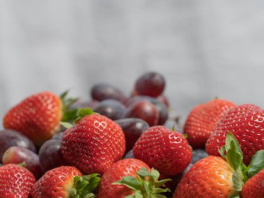 Çilekler ve üzümler üst tarafta. Yakın plan. Tez kavramı, vitaminler.