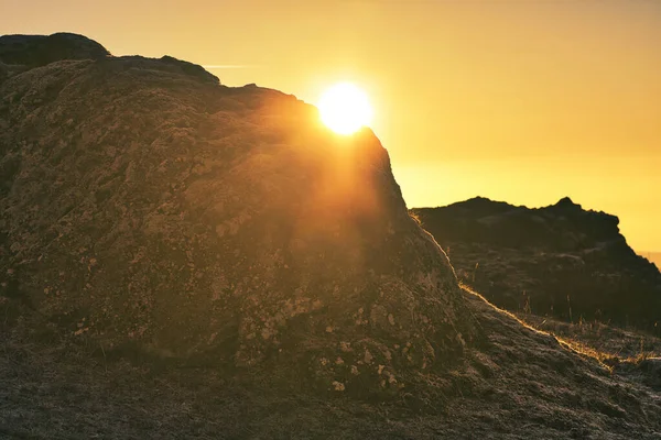 Sun peaking over a rock at winter solstice in germany