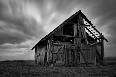 Terk edilmiş eski ürkünç ahır ve çayır manzarası.