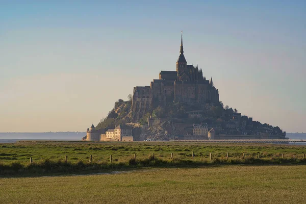 Mont Saint Michel gün batımında ön planda çayırlarla
