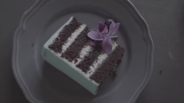 Leckeres Stück türkisfarbener Kuchen mit Blaubeeren, Orchideen auf einem Teller, s-log — Stockvideo