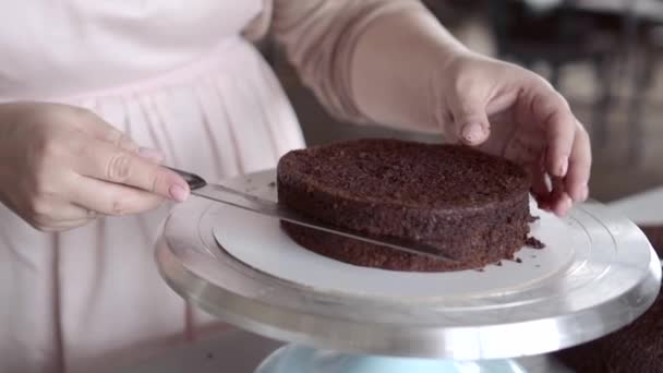 Шеф-повар режет верхушку печенья, чтобы получить гладкую оболочку шоколадного торта — стоковое видео