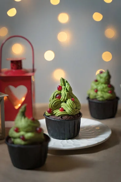 Christmas cupcake with green cream tree with red balls decoration of cowberry Foto Stock