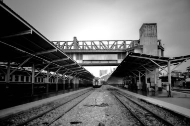 Tren istasyonu çatıları olan siyah ve beyaz tren yolları ve platformları