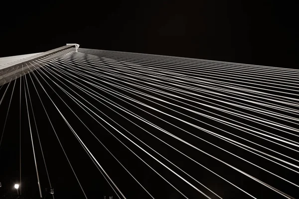黒と白のワイヤーロープは 夜に明るい光を持つ大きな橋を伸ばします — ストック写真