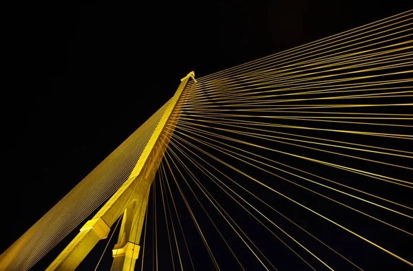 Kablolar gece parlak ışıklarla büyük bir köprüyü gerer. Karınca bakışı.