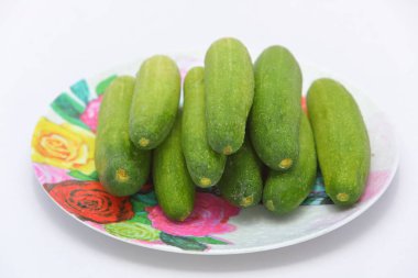 Kapalı tabakta taze salatalıklar ve beyaz arka planda izole edilmiş