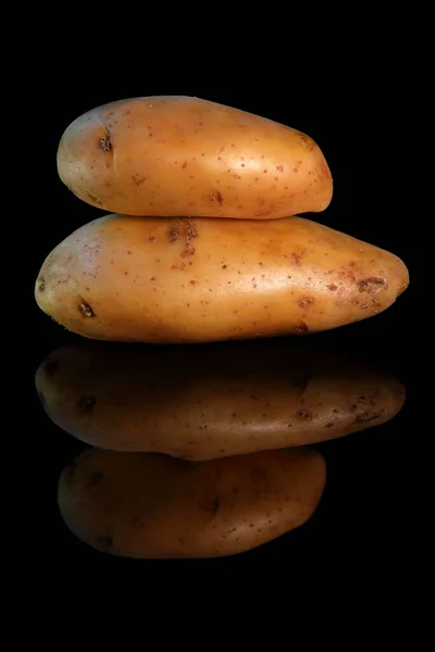 在黑暗的背景上堆积起来的马铃薯 — 图库照片