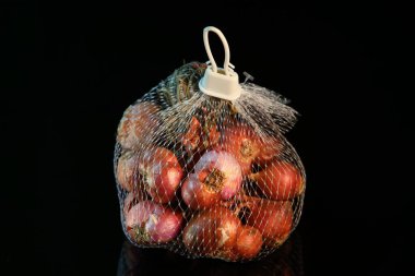 Paket çantasındaki bir grup Allium ascalonicum karanlıkta izole edilmiş.