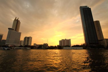 View along the Chao Phraya River, there is a pier for tourists at sunset in Bangkok.