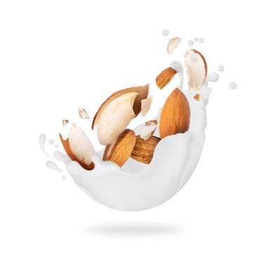 Ezilmiş bademler beyaz arka planda izole edilmiş bir şekilde yakın plan sütü damlatıyor.