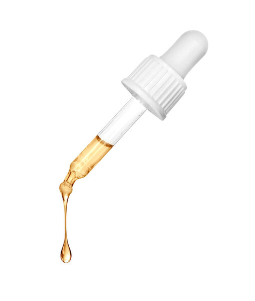 Натянутая маслянистая капля падает с косметического пипетки крупным планом на белом фоне