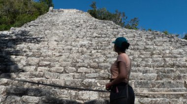 Maya Piramidi Nohoch Mul 'a hayran olan genç turist, antik Maya kenti Coba' da yer alıyor. Burası tatil ve yaz turizmi için ideal bir yer. Ünlü Maya Rivierası..