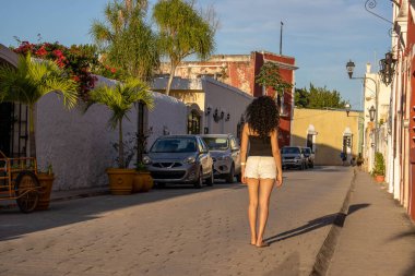 Yucatan yarımadasında (Meksika) Valladolid caddelerinde yürüyen bir turist, Meksika ormanının ortasında renkli ve güzel sokaklar.