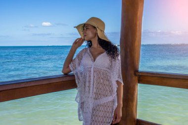 Güzel bir tropikal güneşin altında dinlenen seksi kadın ve heyecanlanıp esintisini yüzünde hissederken Karayip denizinin ufkuna bakan ve Karayipler 'in tadını çıkaran yeryüzündeki cennet, tatil ve turist mekanı.