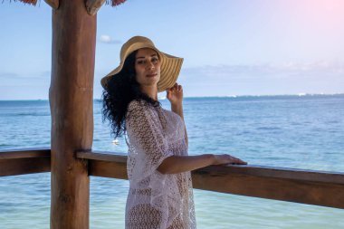 Turkuaz bir Karayip denizi ve tropikal bir güneş üzerine eğilen şapkalı genç kadın, bu dünyadaki en romantik, rahatlatıcı, güzel ve çekici denizlerden biridir..