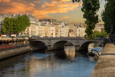 The famous and beautiful small bridge over the Seine River in Paris under the beautiful sunset sky, this is a beautiful Parisian city bridge, very busy French bridge in Paris. Concept bridges in Paris